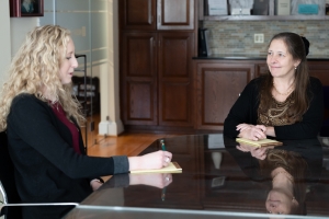 financial planner sitting down at a table with a client discussing annual goals and taxes