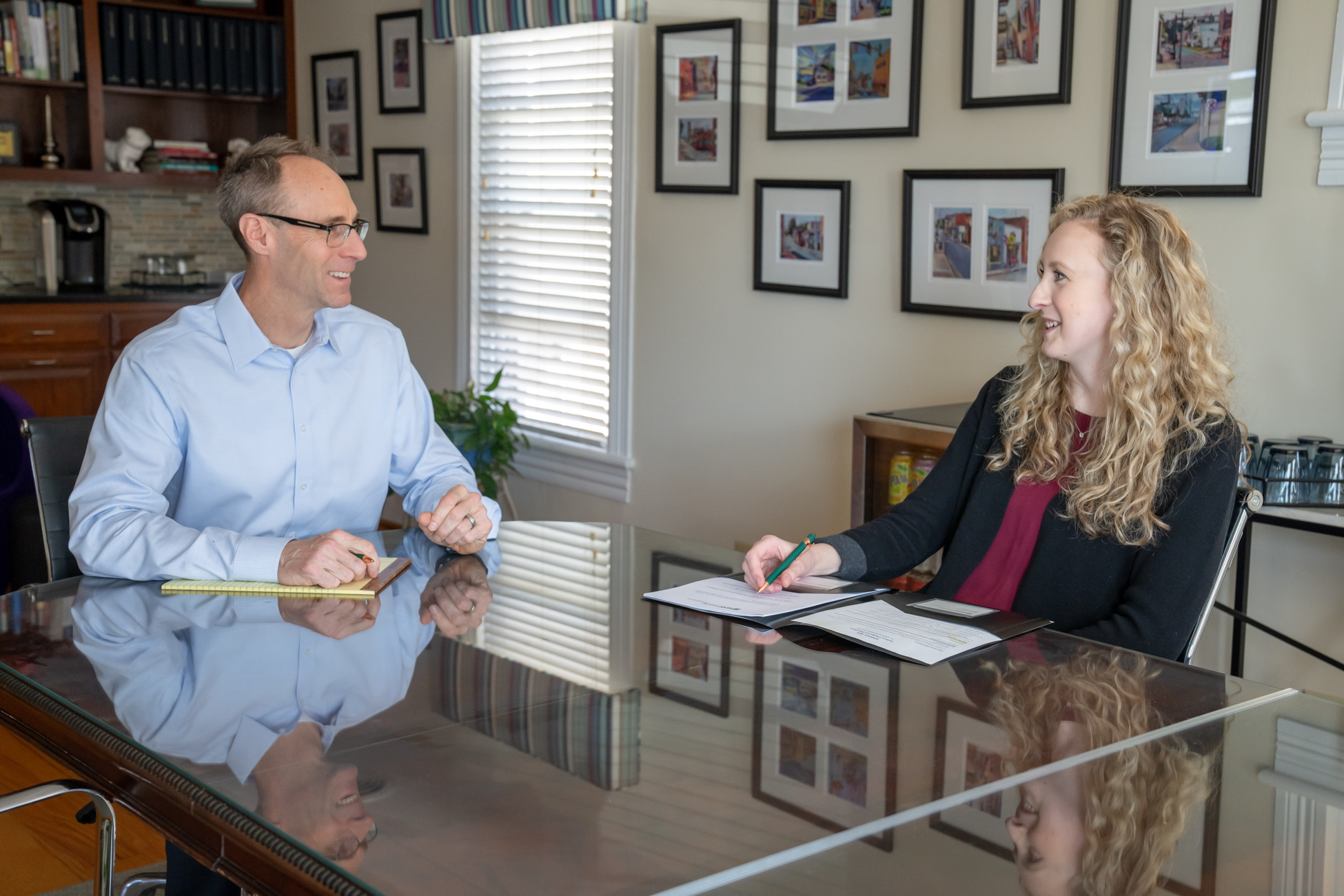 Sara Kate Garman, CPA sitting at a table with Stephen Hess, a financial planner, discussing taxes and investment strategies.