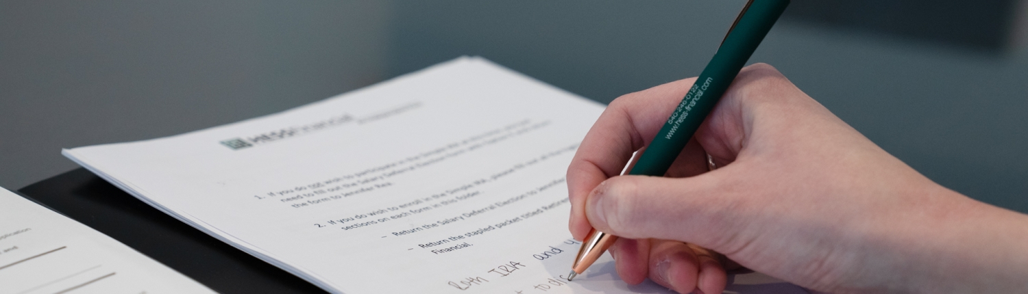 SK writing taking notes during meeting with financial planner about taxes and donor advised funds