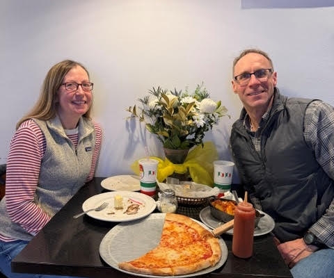 SH Stephan and his wife eating pizza at a restaurant