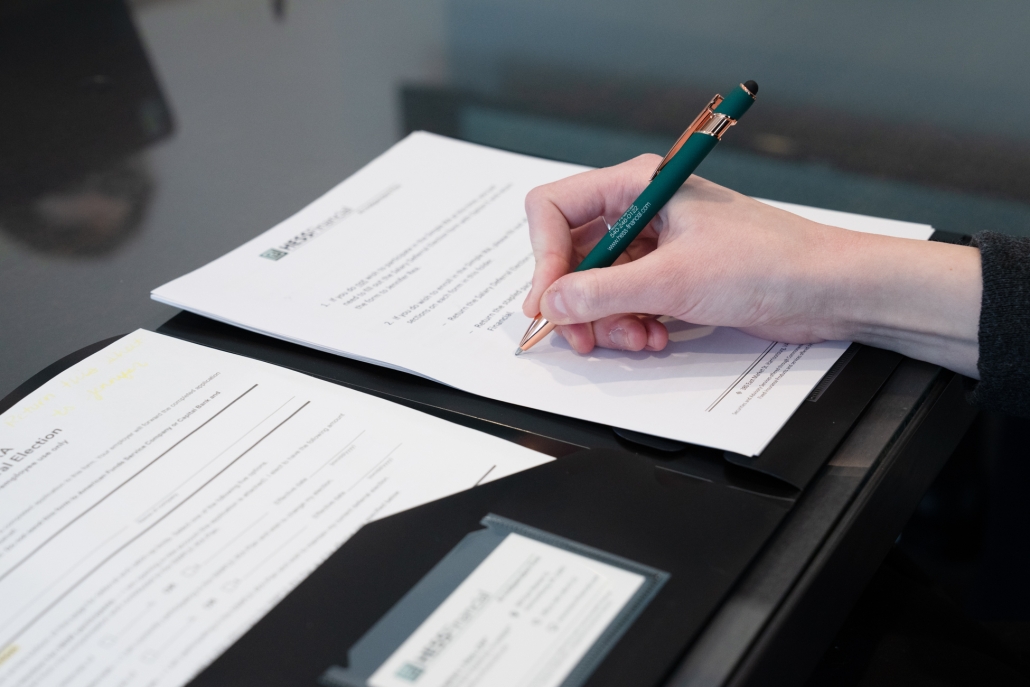DSC05167 Close up of a person's hand signing a Hess Financial document